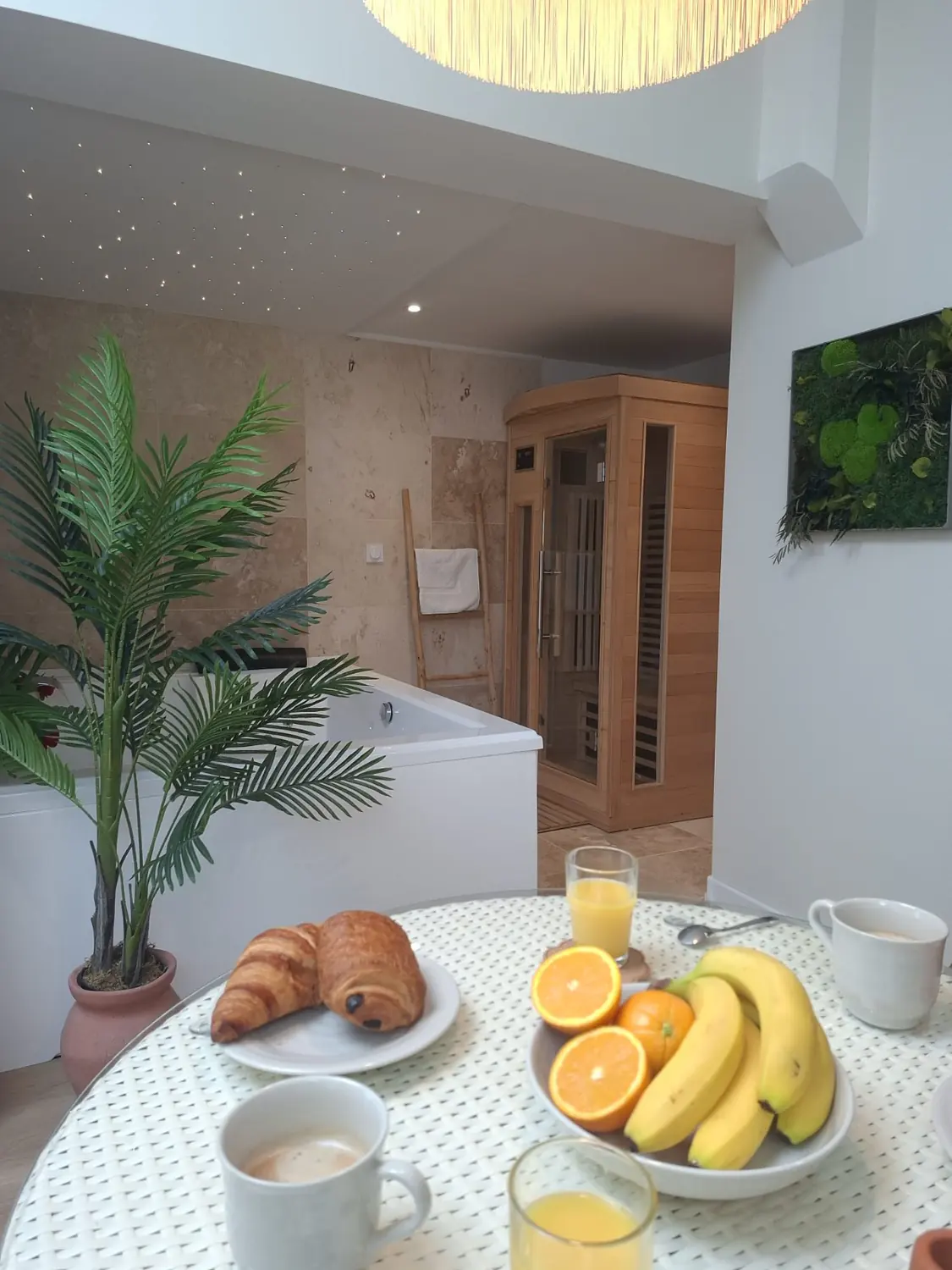 Petit-déjeuner servi avec viennoiseries, café, jus d'orange et fruits frais