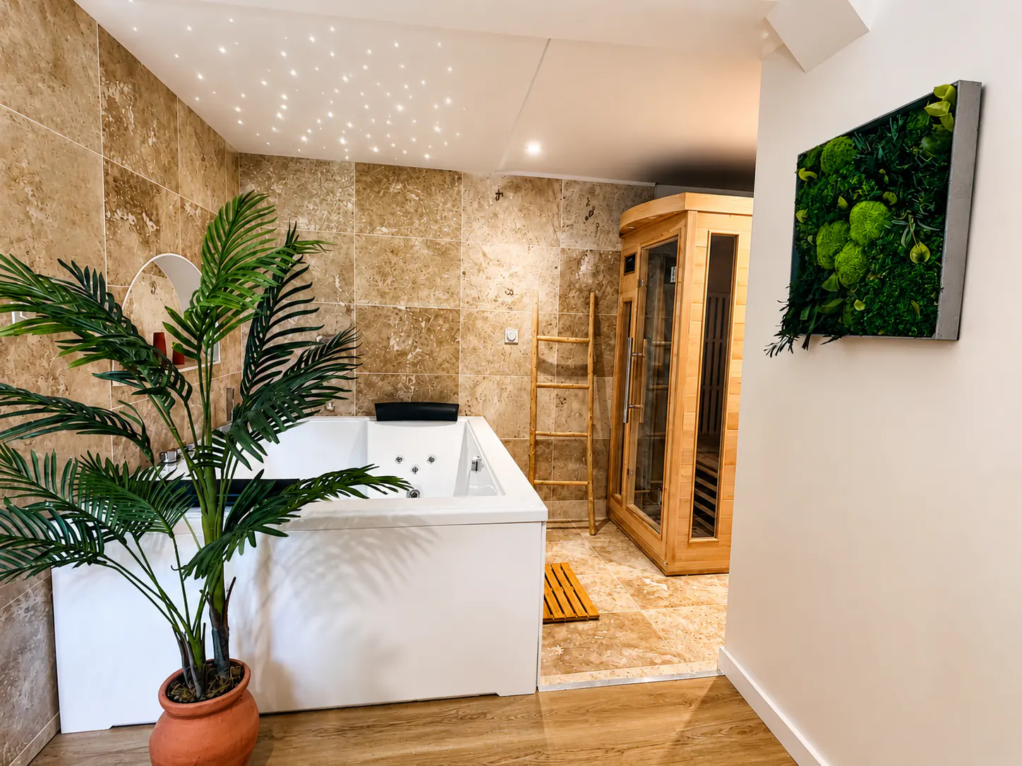 Espace bien-être de La Suite Balinaise, vue large avec baignoire balnéo, sauna privé en bois et ciel étoilé